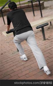 Rear view of a young man exercising in a park