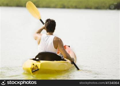 Rear view of a young man kayaking