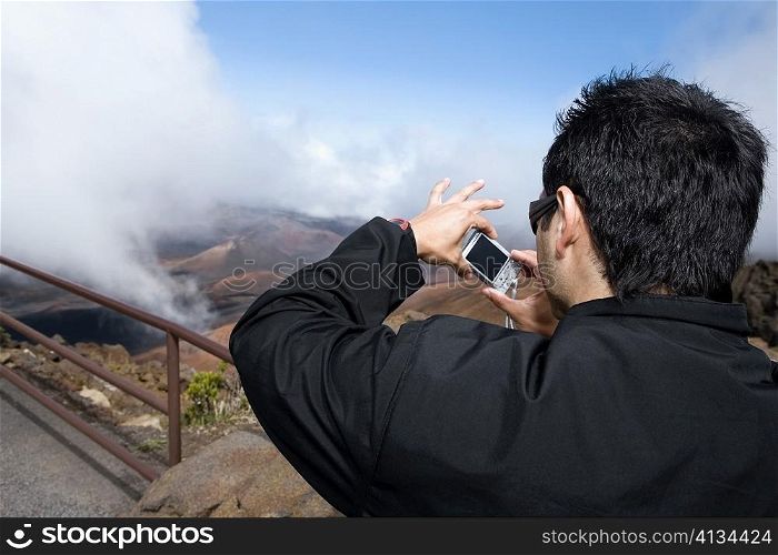 Rear view of a young man taking a photograph, Haleakala National Park, Maui, Hawaii Islands, USA