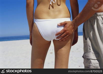 Rear view of a young man touching a young woman&acute;s bottom