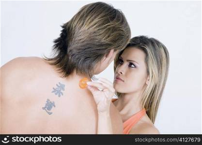 Rear view of a young man with a young woman holding a condom