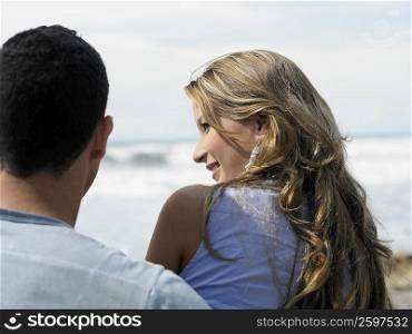 Rear view of a young woman and a man on the beach