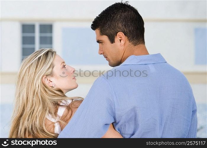 Rear view of a young woman and a mid adult man looking at each other