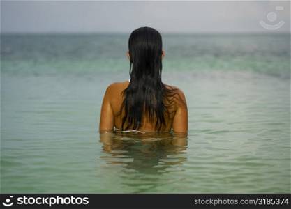Rear view of a young woman in the water