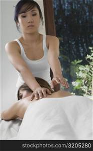 Rear view of a young woman receiving a back massage from a massage therapist