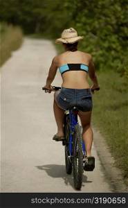 Rear view of a young woman riding a bicycle