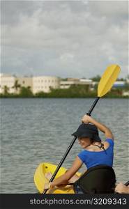 Rear view of a young woman sitting in a kayak