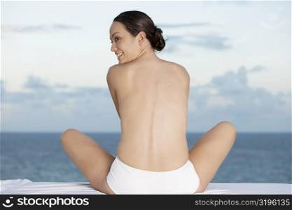 Rear view of a young woman sitting in a lotus position