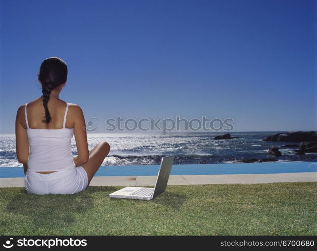 Rear view of a young woman sitting on a lawn