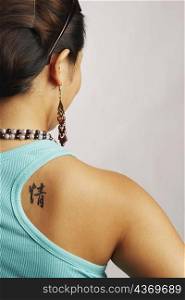 Rear view of a young woman with a tattoo on her back