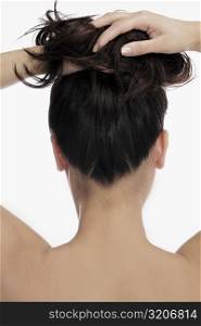 Rear view of a young woman with her hands in her hair