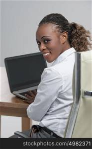 Rear view of african woman working on her laptop