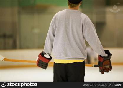 Rear view of an ice hockey player holding an ice hockey stick