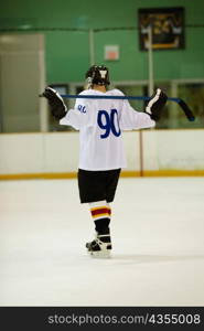 Rear view of an ice hockey player holding an ice hockey stick