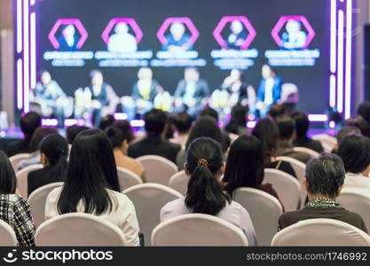 Rear view of Asian audience joining and listening group of speaker talking on the stage in the seminar meeting room or conference hall, business and education, associate and startup business concept