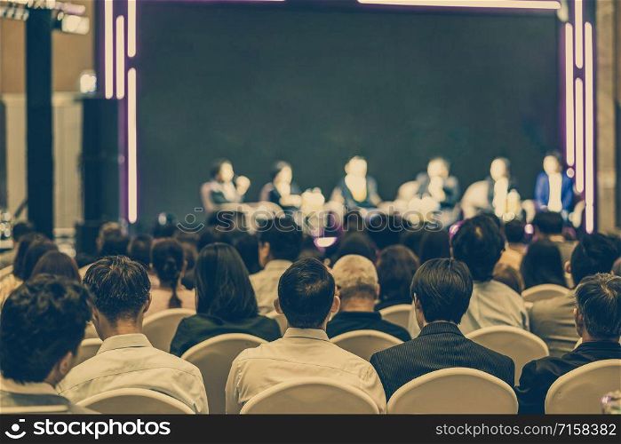 Rear view of Asian audience joining and listening group of speaker talking on the stage in the seminar meeting room or conference hall, business and education, associate and startup business concept