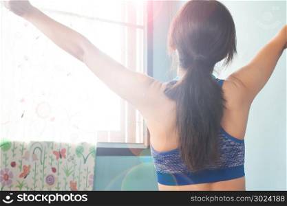 Rear view of Asian woman in sport bra raise up hands in the morning, Healthy concept