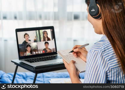 Rear view of Asian woman working and online meeting via video conference with colleague and team building when Covid-19 pandemic,Coronavirus outbreak,education and Social distancing,new normal concept