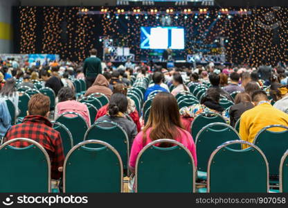 Rear view of Audience in the conference hall or seminar meeting which have Speakers on the stage, business and education about investment concept