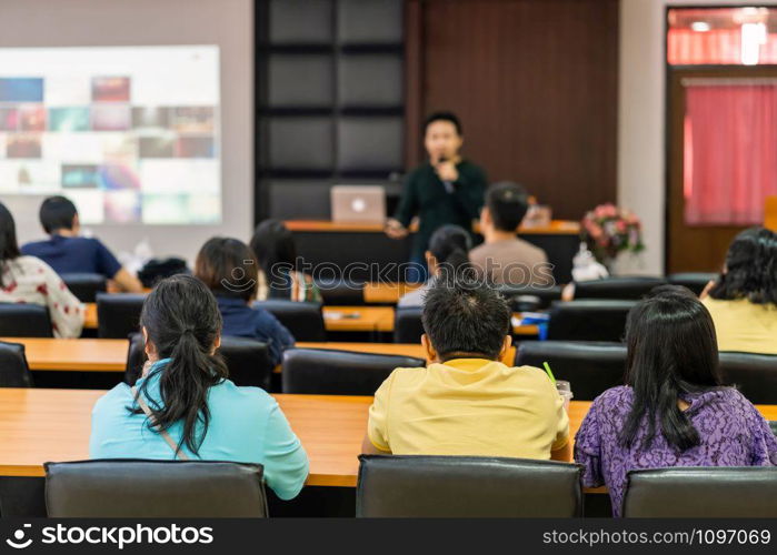 Rear view of Audience listening Speakers on the stage in the conference hall or seminar meeting, business and education about investment concept