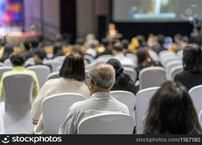 Rear view of Audience listening Speakers on the stage in the conference hall or seminar meeting, business and education about investment concept