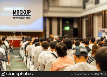 Rear view of Audience listening Speakers on the stage with presentation via projector in the conference hall or seminar meeting and workshop event, business and education about investment concept