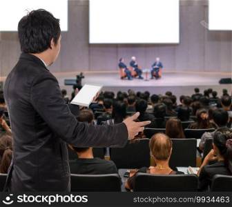 Rear view of Business People Conference Speaker on over the Abstract blurred photo of conference hall or seminar room with attendee background, business seminar and education concept