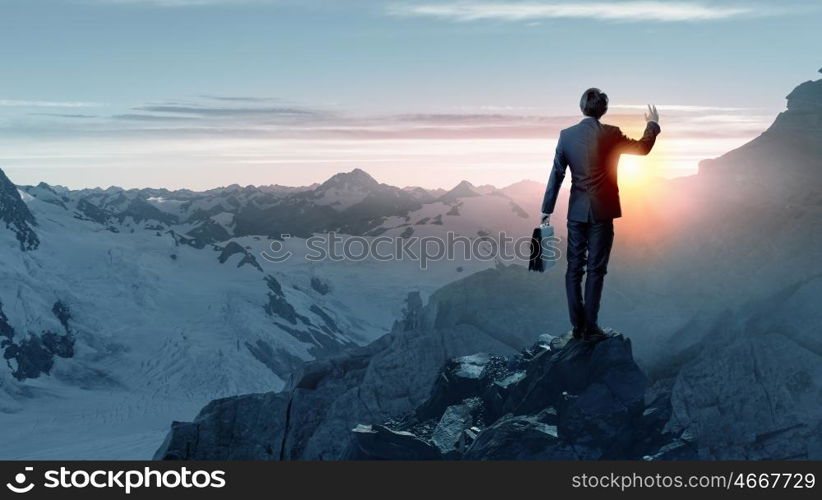 Rear view of businessman look at sunrise above mountain. Facing new day