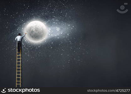 Rear view of businessman standing on top of ladder. Reaching moon