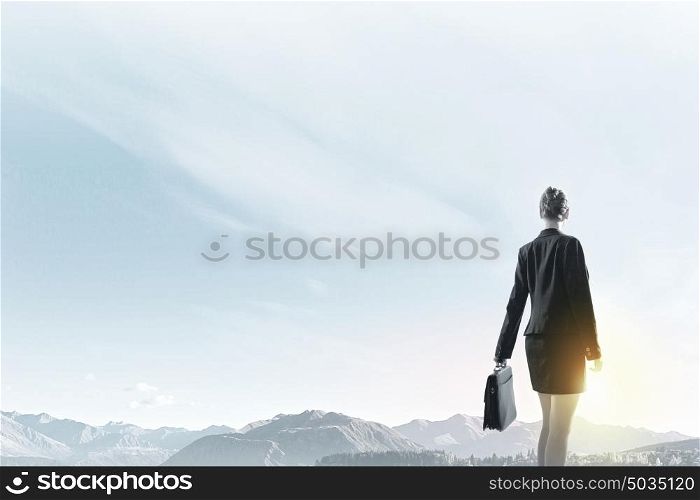 Rear view of businesswoman look at sunrise above city. Facing new day