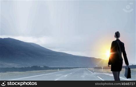 Rear view of businesswoman look at sunrise above mountain. Facing new day