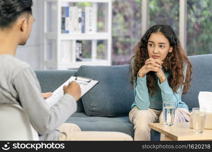 Rear view of coach listening and looking Asian young woman is sadness about their problem, Psychologist couple and hypnosis deny and argue,life coach and coaching in private indoor home concept