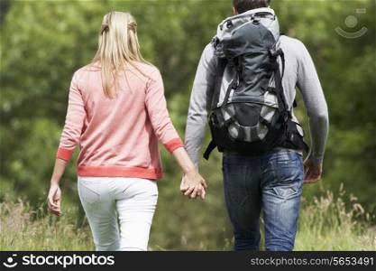 Rear View Of Couple Hiking In Countryside