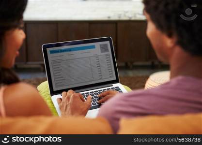 Rear View Of Couple Using Online Banking On Laptop