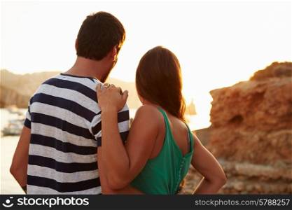Rear View Of Couple Watching Sunset Over Harbour