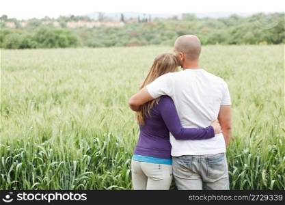 Rear view of couple with arms around each other in the park
