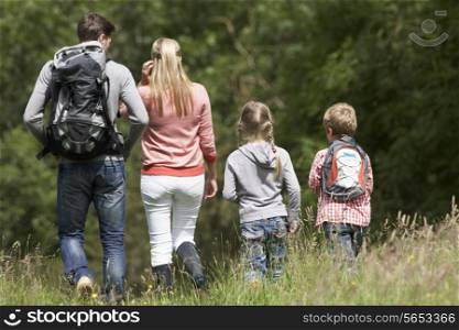 Rear View Of Family Hiking In Countryside