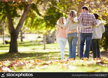 Rear View Of Family Walking Through Autumn Woodland