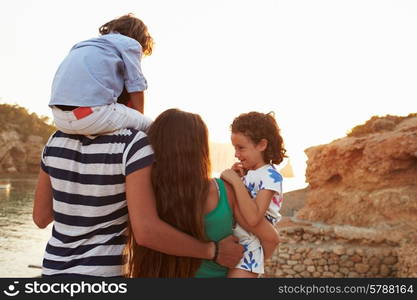 Rear View Of Family Watching Sunset Over Harbour