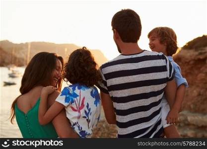 Rear View Of Family Watching Sunset Over Harbour