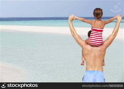 Rear View Of Father Carrying Daughter On Beach Holiday