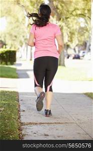 Rear View Of Female Runner Exercising On Suburban Street
