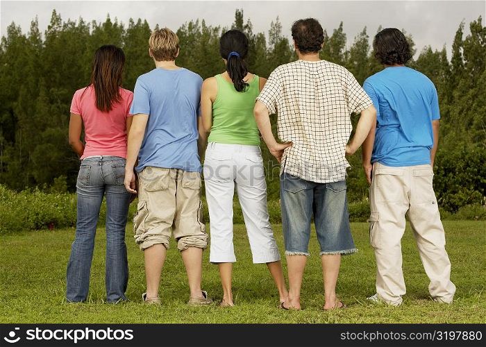 Rear view of five people standing side by side