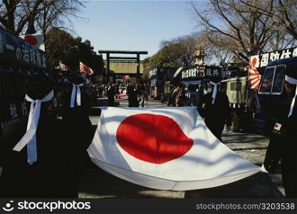 Rear view of four people carrying a Japanese flag, Yasukuni Shrine, Tokyo Prefecture, Japan