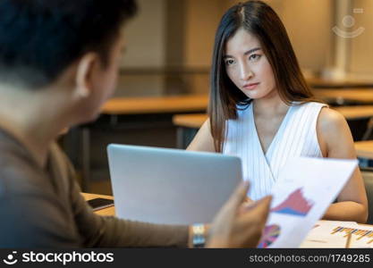 Rear view of Furious boss scolding Asian young businesswoman in casual suit by point to her face about performance and KPI in modern office, Business mistake and punish concept