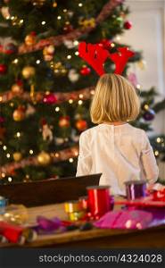 Rear view of girl by Christmas tree