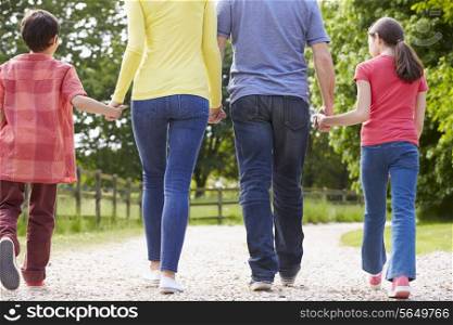Rear View Of Hispanic Family Walking In Countryside