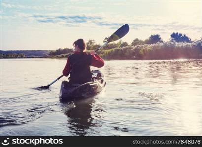 Rear view of kayaker paddle kayak in summer river