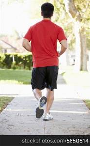 Rear View Of Male Runner Exercising On Suburban Street