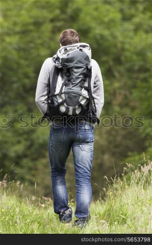 Rear View Of Man Hiking In Countryside